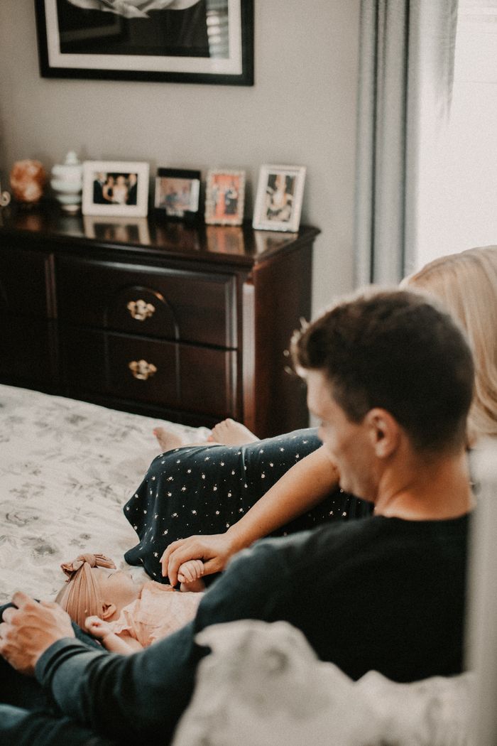 A loving family enjoying a quiet moment together in their cozy bedroom.