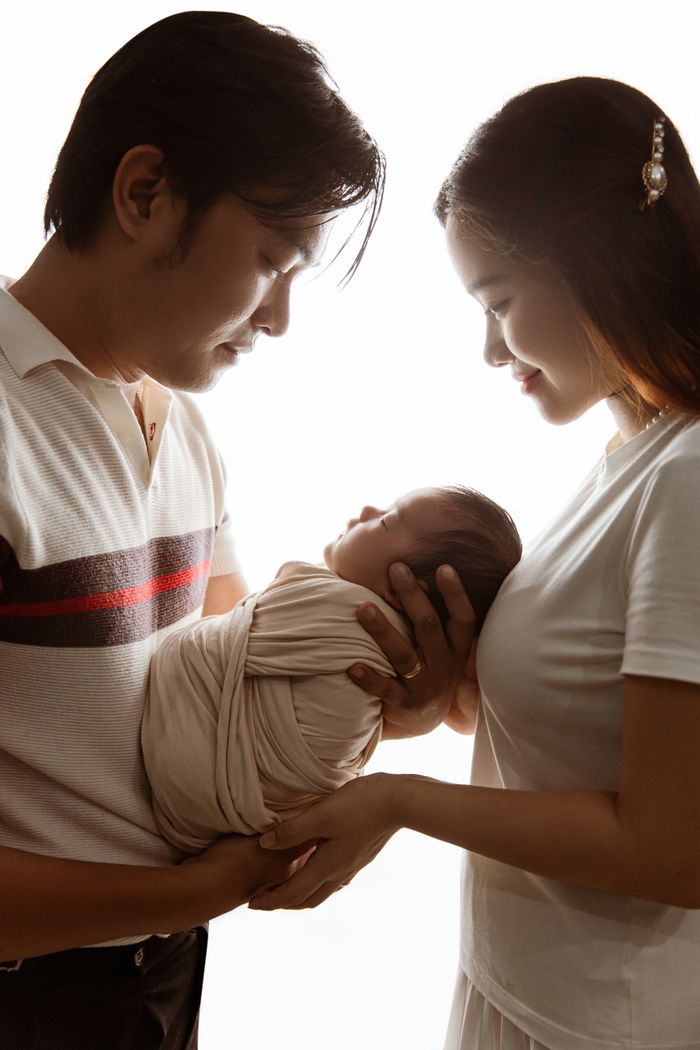 about-img A loving couple holds their newborn, capturing a tender family moment with warmth and care.