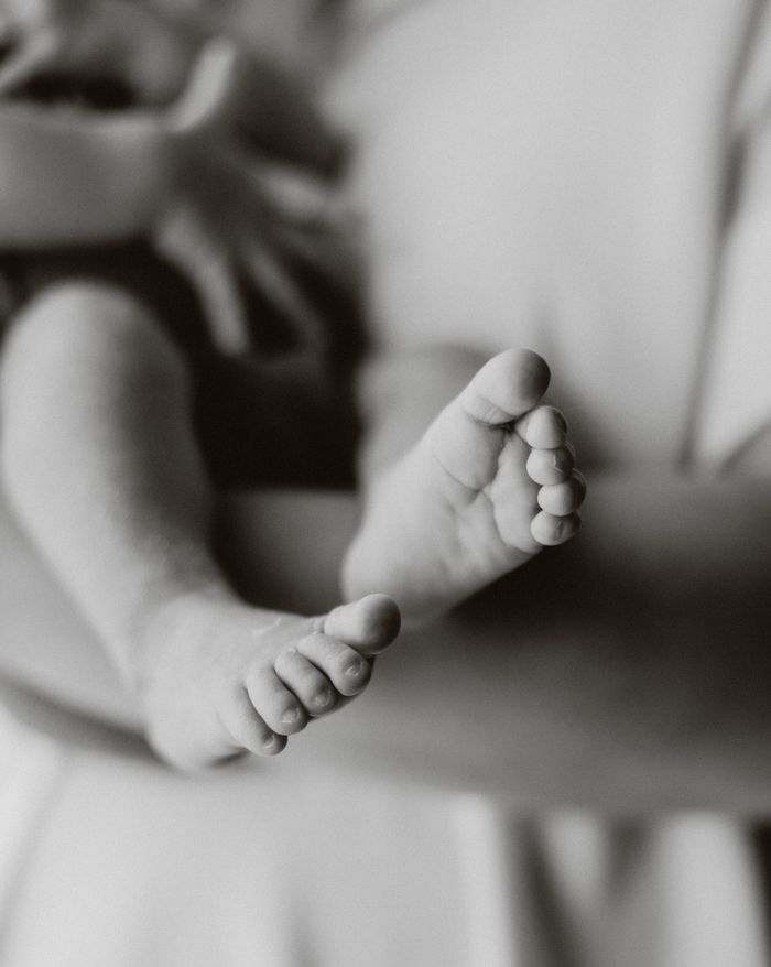 our-experience A close-up shot of a baby's feet in black and white, capturing tender moments.